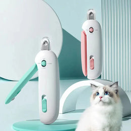 Pet grooming clippers in white with pink and green accents displayed with a fluffy blue-eyed cat