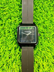 Universe Point classic black square dial wristwatch with black strap on green grass background