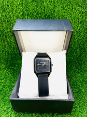 Universe Point classic black square dial wristwatch with black strap on white cushion in black box on green grass